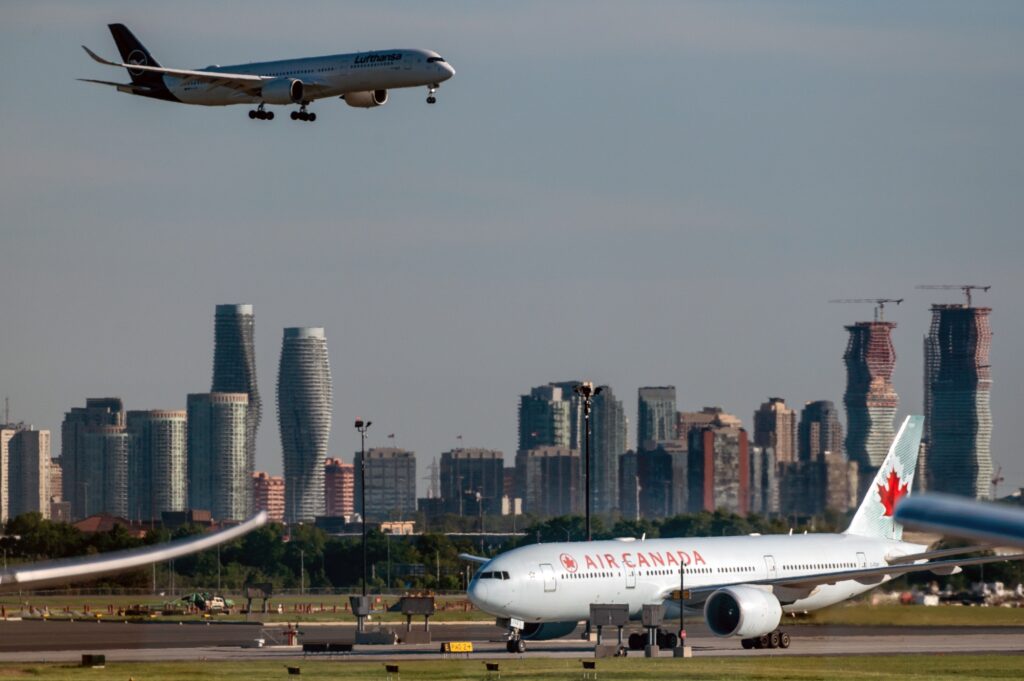 Airplane flying above the clouds, representing the Toronto to New York Flight Duration and travel experience